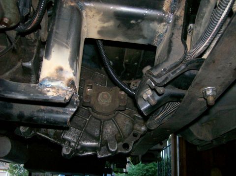 1989 Ford Bronco - Close-up of the vehicle's transmission and frame, showing modifications and wear.
