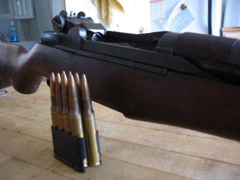 1996 Ford Bronco - Close-up of an M1 Garand rifle and its ammunition clip on a wooden surface.
