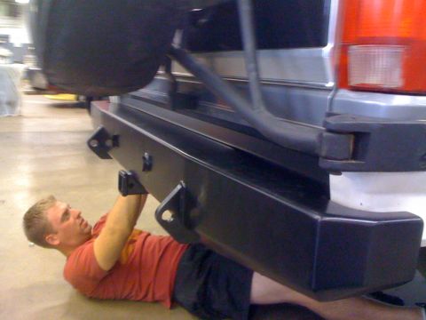 1995 Ford Bronco - Working on the rear bumper of a 1995 Ford Bronco, spare tire mounted above.