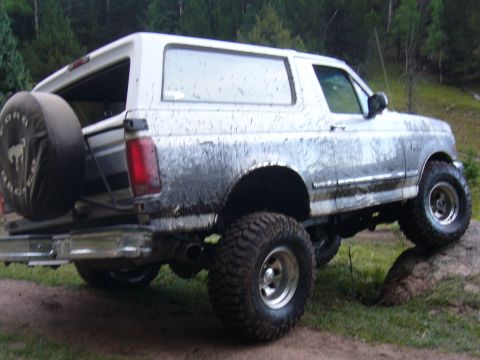1995 Ford Bronco - This lifted 1992 Ford Bronco is covered in mud, showing its off-road capabilities.