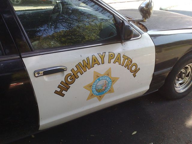 Side view of a 1991 Ford Crown Victoria California Highway Patrol car, showing the door with 'HIGHWAY PATROL' text and badge