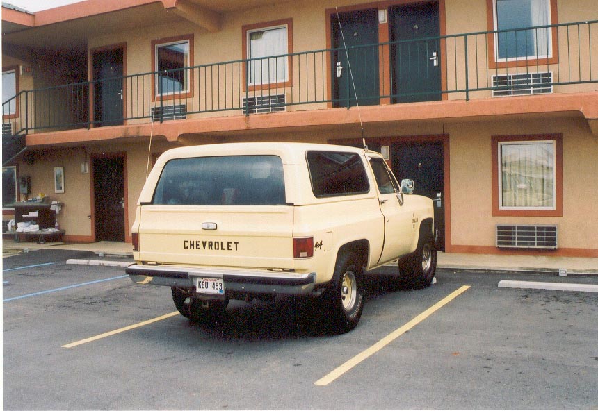 Cream Chevrolet K5 Blazer 4x4 parked at a two-story motel, rear three-quarter view