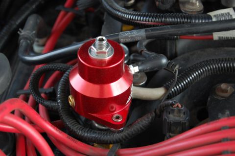 1985 Mercury Grand Marquis - A red aftermarket fuel pressure regulator is installed in the engine bay, surrounded by various hoses and wires.