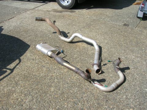 1996 Ford Bronco - Exhaust system components laid out on a concrete surface.