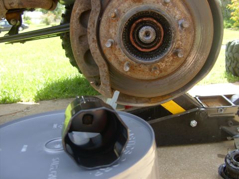 1995 Ford Bronco - Close-up of a vehicle's front wheel hub assembly, showing brake components and a large socket wrench.