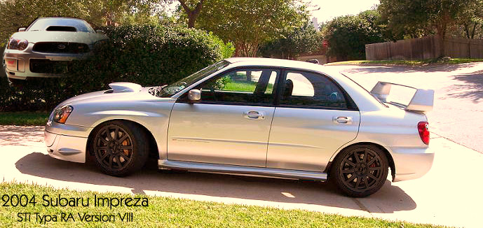 Silver Subaru Impreza sedan, side view, with a large rear spoiler and black wheels parked on a driveway