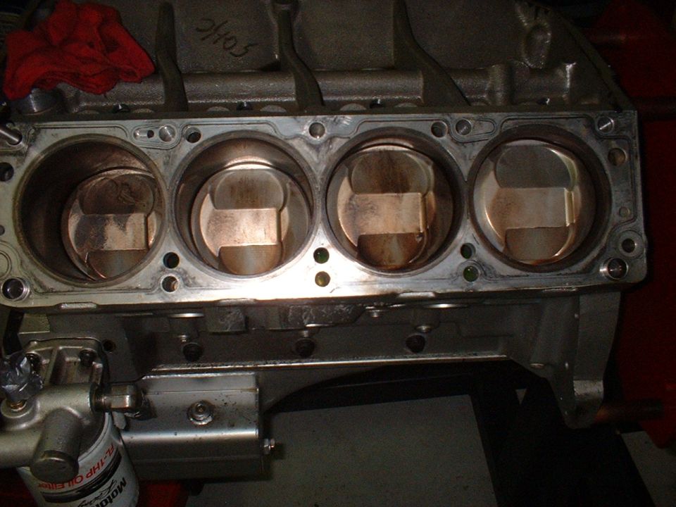 Engine block with four pistons visible, oil filter attached. Text '2H05' written on top