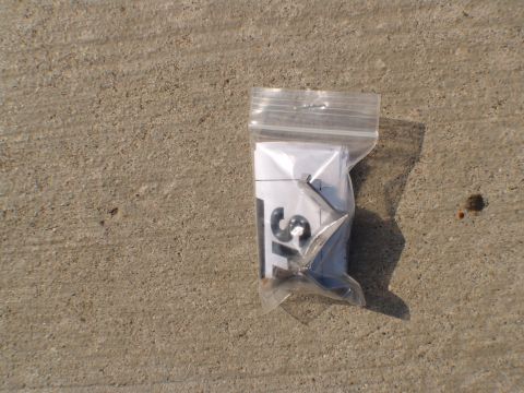1996 Ford Bronco - A small plastic bag contains paper and metal components, possibly for a vehicle part.