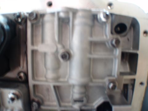 1996 Ford Bronco - A detailed view of a transmission valve body, showing its metallic components and bolt fastenings.