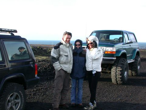 1996 Ford Bronco - Three people pose with two SUVs, a lifted Ford Bronco and a Jeep Cherokee, in an outdoor landscape.