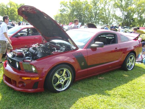 2007 Ford Mustang - Red 2007 Ford Mustang with hood open at an outdoor car show.