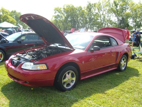2007 Ford Mustang - A red Ford Mustang is displayed with its hood and trunk open at an outdoor event.