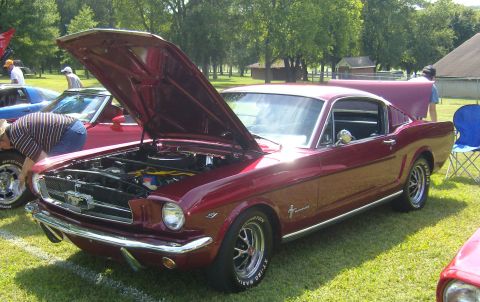 2007 Ford Mustang - A classic red 1965 Ford Mustang coupe is displayed with its hood open at an outdoor event.