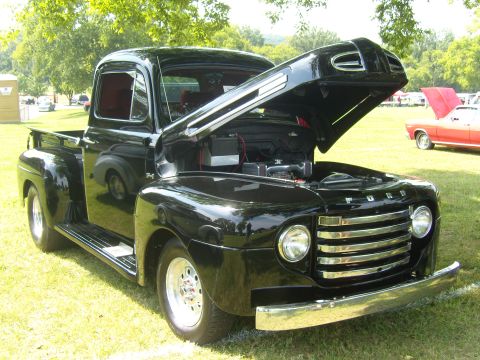2007 Ford Mustang - Black 1948 Ford F-series pickup truck with its hood open, parked on grass.