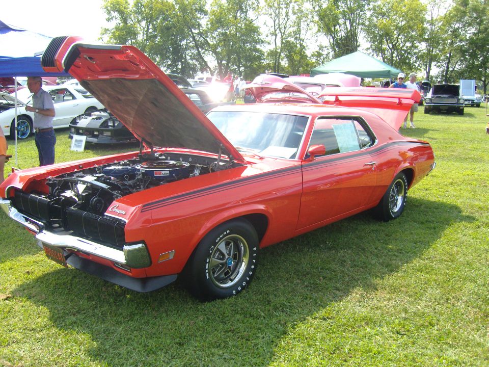Red cougar with hood open, showing engine. Black racing stripes on side and hood. Chrome wheels