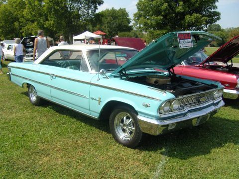 2007 Ford Mustang - A light blue 1963 Ford Galaxie 500 is displayed with its hood open, a "FOR SALE" sign.