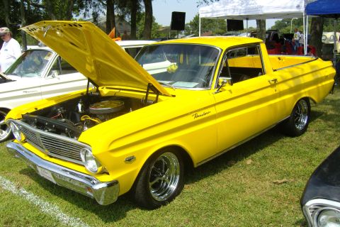 2007 Ford Mustang - A bright yellow Ford Falcon Ranchero is displayed with its hood up at an outdoor event.