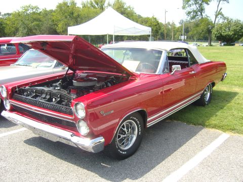 2007 Ford Mustang - This red convertible, likely a 1967 model, is displayed with its hood open, revealing the engine compartment.