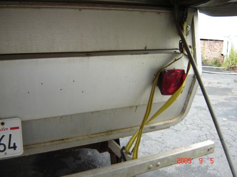 1993 Ford Bronco - Close-up of a trailer's rear, showing a red taillight and a partial license plate with the number 64.