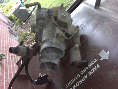 1995 Ford Bronco - Close-up of a throttle body assembly, likely a replacement part.