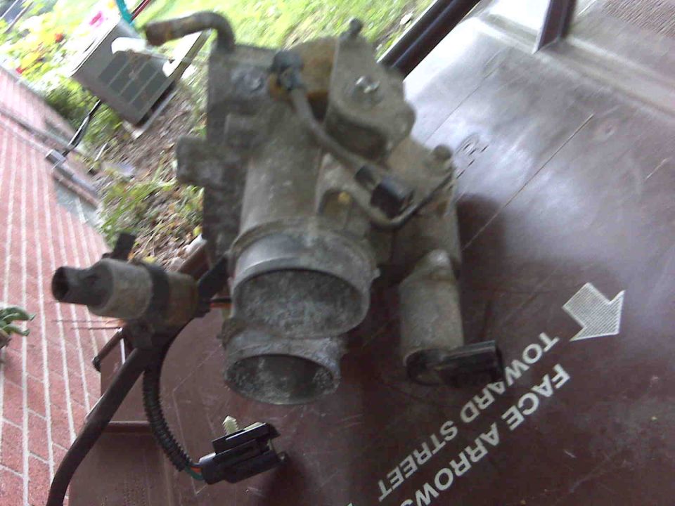 Automotive throttle body assembly with electrical connectors and hoses