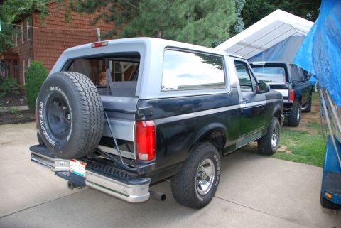 1995 Ford Bronco - Rear view of a 1995 Ford Bronco, showing its spare tire mount and two-tone paint scheme.