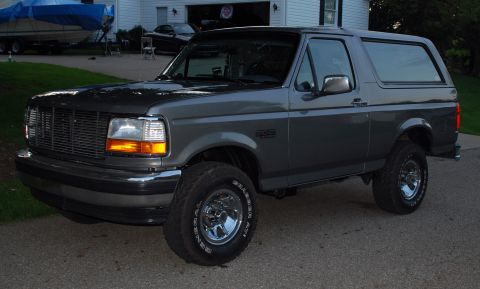 1995 Ford Bronco - This Ford Bronco is parked in front of a house with a boat and another car in the background.
