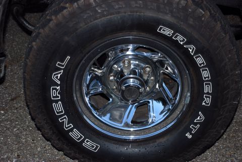 1995 Ford Bronco - Close-up of a chrome wheel with a General Grabber AT2 tire mounted.