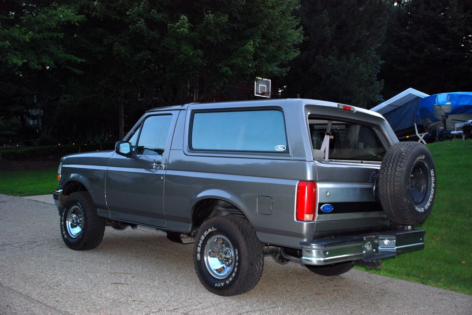 Gray 1995 Ford Bronco parked on a driveway with trees in the background