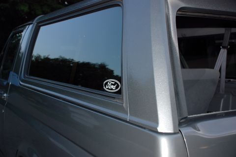 1995 Ford Bronco - A Ford oval sticker is visible on the rear side window of this gray Ford Bronco.