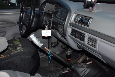 1995 Ford Bronco - The interior of a truck shows the dashboard, steering wheel, and aftermarket shifter.