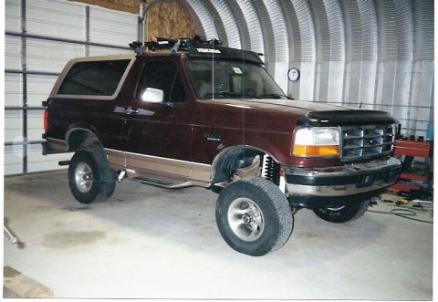 1996 Ford Bronco - This lifted Ford Bronco is in a garage with its front tire off the ground.