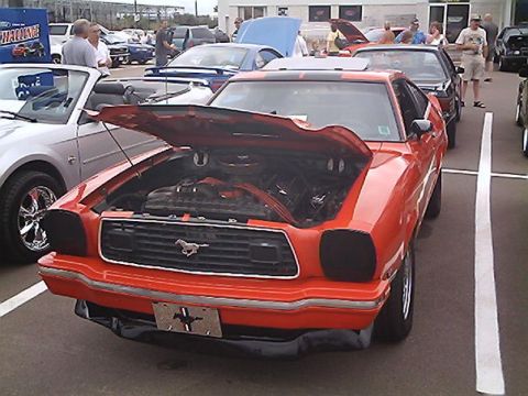 1978 Ford Mustang II - Front view of an orange 1978 Ford Mustang II with its hood open at an outdoor car event.
