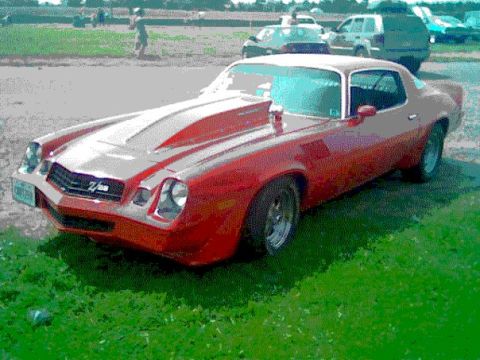 1978 Ford Mustang II - This red 1978 Chevrolet Camaro Z/28 features a prominent hood scoop and racing stripes, viewed from the front three-quarter angle.