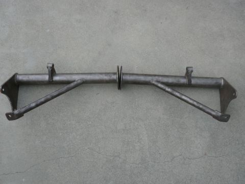 1988 Ford Bronco - This metal part, likely a suspension or frame component, is shown against a concrete surface.
