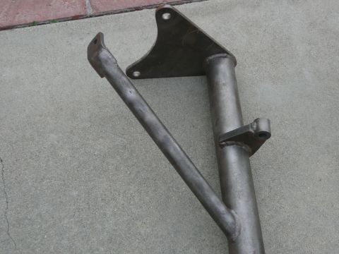 1988 Ford Bronco - A metal bracket and tube assembly is shown resting on a concrete surface.