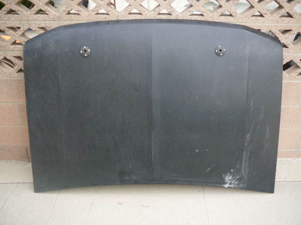 Black car hood with two circular mounting points visible