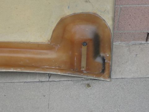 1988 Ford Bronco - A fiberglass part with visible mounting hardware sits on a concrete and brick surface.