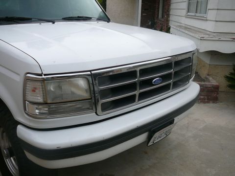 1988 Ford Bronco - Front view of a white Ford truck, showing its grille and headlight assembly.