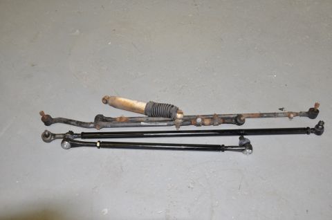 1996 Ford Bronco - Various steering linkage components and a shock absorber are displayed on a flat surface.