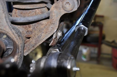 1996 Ford Bronco - Detail of vehicle suspension components, showing rust and a metal rod with fasteners.