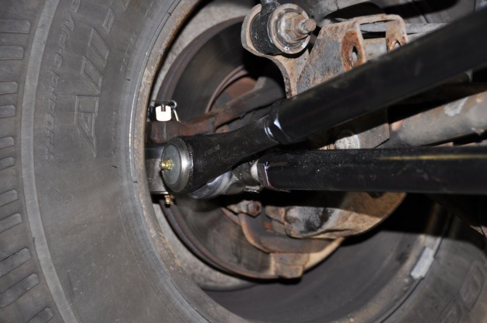 Close-up of front wheel steering linkage and tire