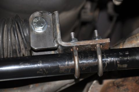 1996 Ford Bronco - Custom bracketry attached to a vehicle's steering rack, showing a bolted connection and clamped connection.
