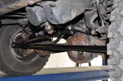 1996 Ford Bronco - Close-up of the steering and suspension system on a vehicle's undercarriage.