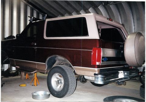 1996 Ford Bronco - This Ford Bronco is elevated on jack stands inside a metal-sided structure.
