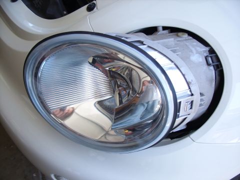 2003 Volkswagen Beetle - Close-up of a removed headlight assembly from a white 2003 Volkswagen Beetle.