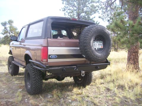 1993 Ford Bronco - Rear view of a 1993 Ford Bronco parked outdoors, an aftermarket bumper and spare tire.