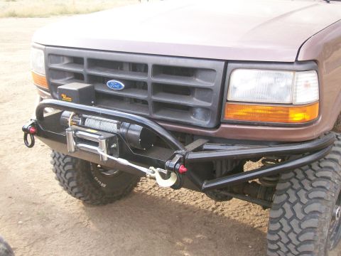 1993 Ford Bronco - This Ford truck features an aftermarket bumper with a winch and tow hooks, mounted below the factory grille.