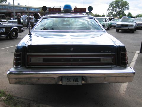 1991 Ford LTD Crown Victoria - Straight-on rear view of a blue Ford LTD sedan showing FORD and LTD badging, full-width taillights and a license plate reading 150-WWL.