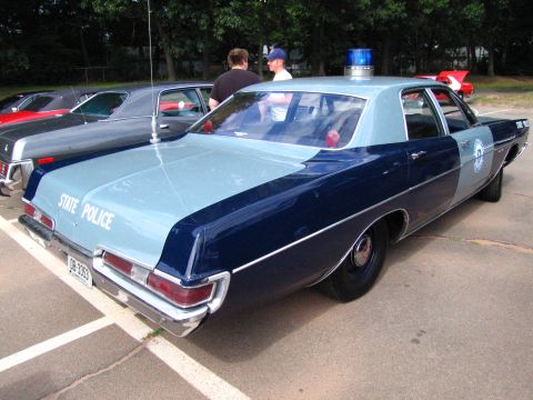 1991 Ford LTD Crown Victoria - two-tone blue full-size 1970s sedan marked STATE POLICE with a roof beacon, parked at an outdoor show.